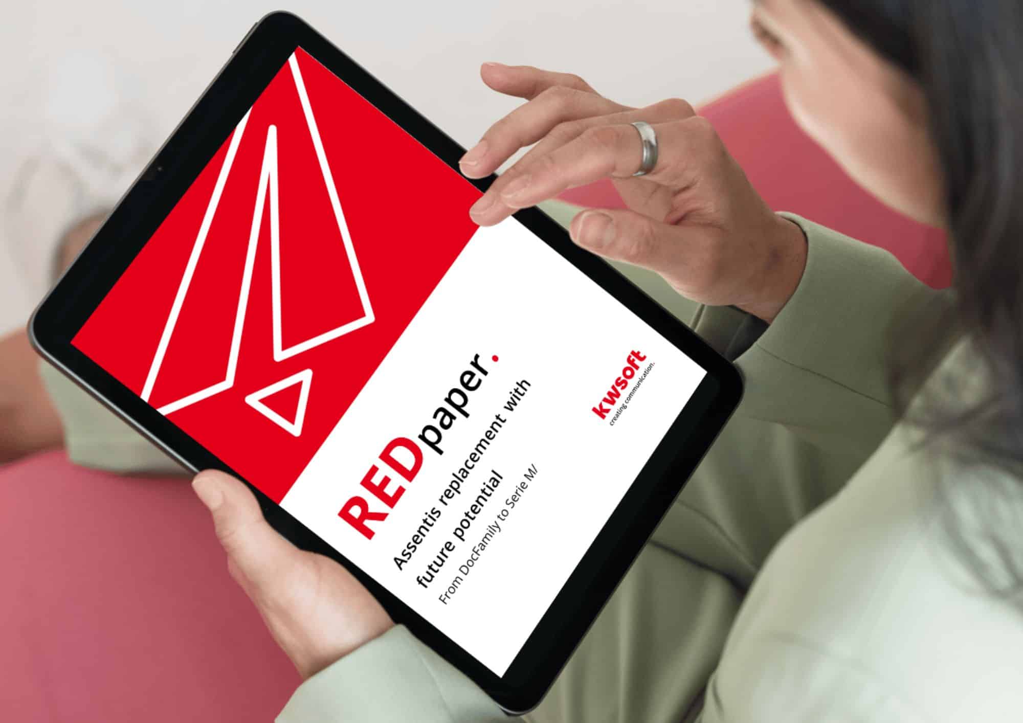 Zdjęcie przedstawia tablet trzymane przez osobę, na którym widoczna jest okładka publikacji REDpaper „Assentis Replacement”.
