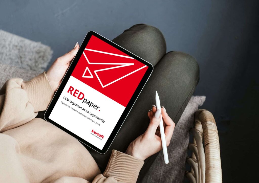 Zdjęcie przedstawia tablet trzymane przez osobę, na którym widoczna jest okładka publikacji REDpaper „CCM – Migration”.